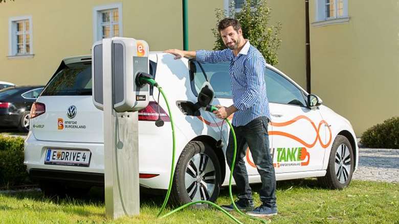 Mann tankt bei der E-Tankstelle 