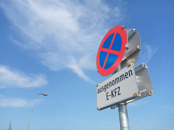 Verkehrsschild Halten und Parken verboten ausgenommen E-KFZ vor blauem Himmel