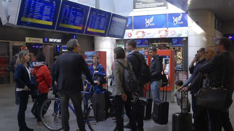 Teilnehmer am Hauptbahhnhof in Wien vor der Abfahrtstafel