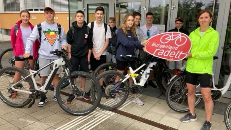 Gruppenfoto mit SchülerInnen und Tina Wurm vor der Schule mit Burgenland radelt Schild