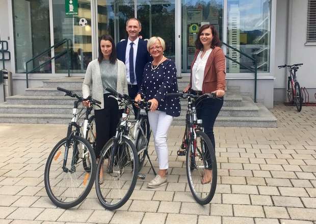 Landesrätin Astrin Eisenkopf mit Bürgermeisterin Salamon, Peter Zinggl und einen weiteren Person vor dem Rathaus mit einem Fahrrad