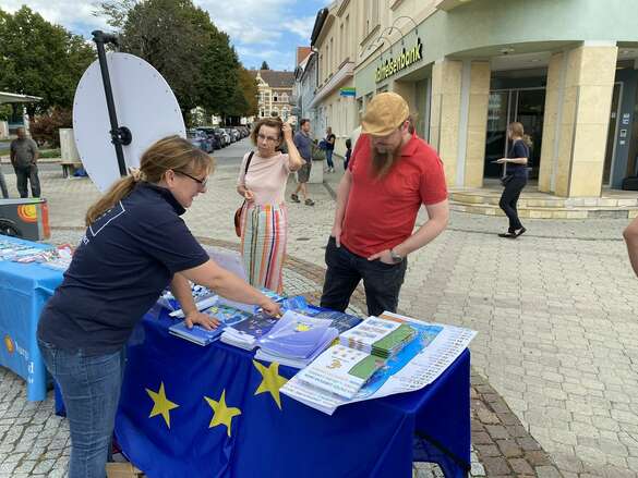 Frau berät Besucher beim Infostand