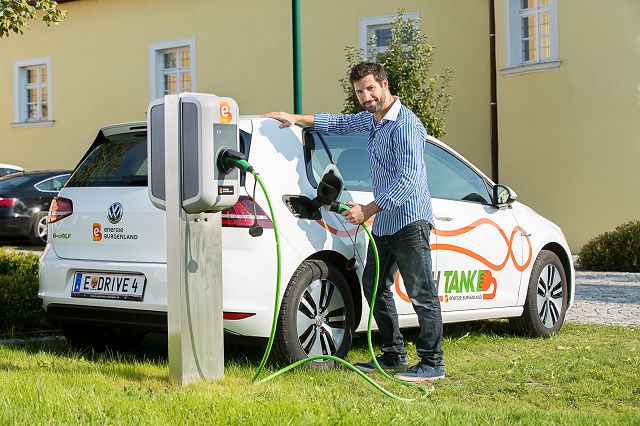 Mann tankt bei der E-Tankstelle 